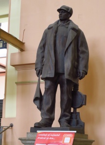 A statue of a member of the proletariat stands guard, reminding comrades of the central importance of the working man, as opposed to a bloke on a horse, to the working man's paradise.